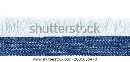 Blue denim border with fringes close-up, place for text, copy space. Royalty-Free Stock Photo #2031055478