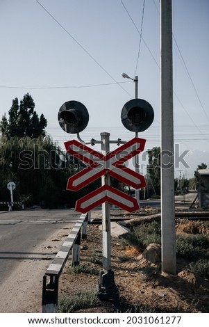 Stop - railway crossing. Crossbuck and stop sign on countryside road and railway . Vertical shot 