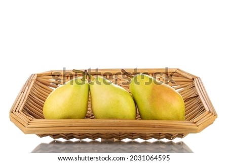 Three bright yellow juicy pears with a basket, close-up, isolated on white.