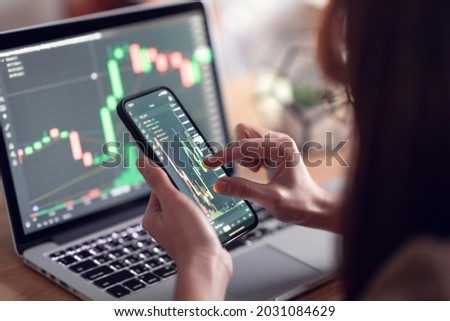 Closeup - Woman is checking Bitcoin price chart on digital exchange on smartphone, cryptocurrency future price action prediction. Royalty-Free Stock Photo #2031084629