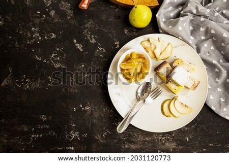 Pear jam and pie are on a white plate. Black background. Copy space. Sweet breakfast and snack