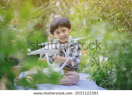 Kid playing drone. Little Pilot Using Drone Remote Controller. Young cute boy holding quadcopter at home. Child playing with drone. Education, home studying, children, technology