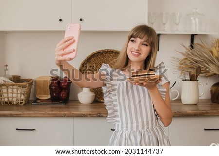 A housewife or pastry chef takes a selfie with dessert. Food blog. Cooking courses. Blogger girl.
