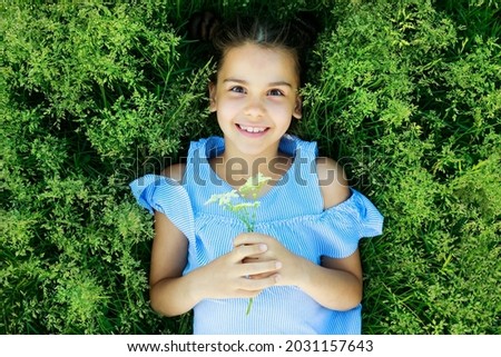 a beautiful girl in blue clothes in nature in the summer in the park. fashionable kid. High quality photo