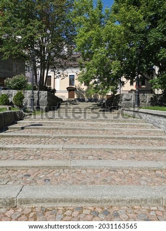 A large, wide, stone staircase in the park on a sunny summer day in Vyborg.