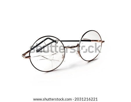 The glass of the eyeglasses cracked on both sides. Placed on a white background. Isolated. Royalty-Free Stock Photo #2031216221