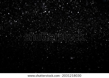 Best photo of real falling medium sized snowflakes out of focus on black background for overlay blending mode. Royalty-Free Stock Photo #2031218030