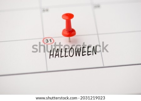 Above photo of label date 31 october inscription halloween and red pin isolated on the calendar background