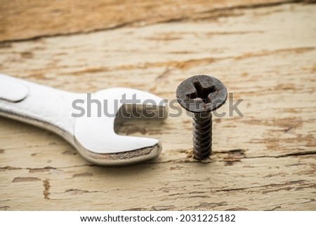 Wrong tool for this job. Screw and open end wrench on old wooden background. Recruitment, HR human resources management in business company, put the right man on the right job concept.