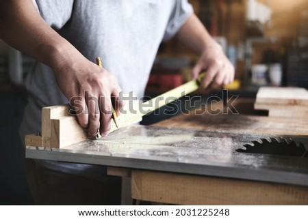 do-it-yourself concept Craftsmen use a tape measure to assemble wooden pieces to make wooden tables for customers.