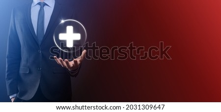Businessman hold virtual plus medical network connection icons. Covid-19 pandemic develop people awareness and spread attention on their healthcare