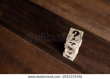 Stacked wooden cube with question mark on table. Concept of FAQ, questions, uncertainty and riddle Royalty-Free Stock Photo #2031319346