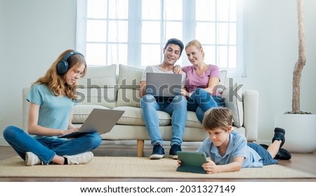 Close up portrait of caucasian family parents daughter and son sit on sofa living room hands using smart phones technology. Together leisure time isolation, home quarantine stay together concept  Royalty-Free Stock Photo #2031327149