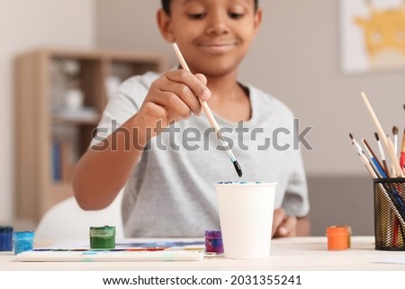 Little African-American boy painting at home