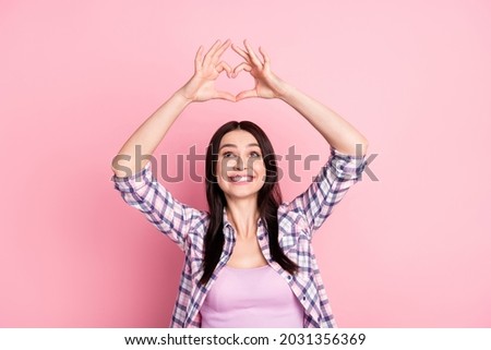 Photo of lovely happy sweet young woman look make fingers heart shape isolated on pink color background