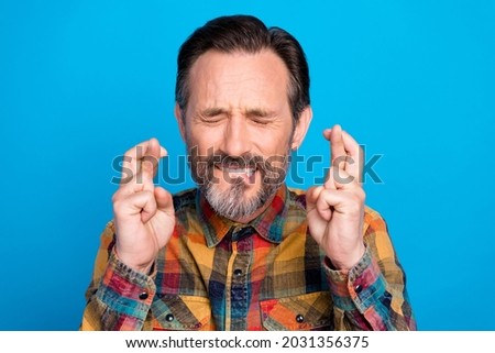 Photo of beg brunet hairdo age man crossed fingers wear plaid shirt isolated on blue color background