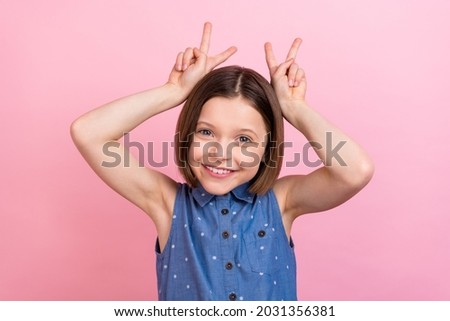 Portrait of attractive cheerful girlish girl showing v-sign like ears isolated over pink pastel color background