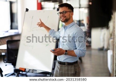 Businessman present his idea to working team. Young happy manager presenting businessplan.	 Royalty-Free Stock Photo #2031358580