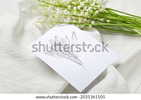 Tray with beautiful lily-of-the-valley flowers and greeting card on light background