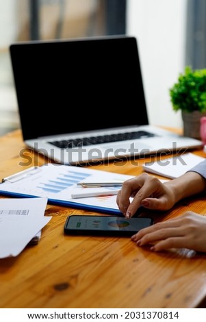 Close up of Accounting business woman working on smartphone note laptop computer and analyzing real estate investment data, Financial and tax systems concept.