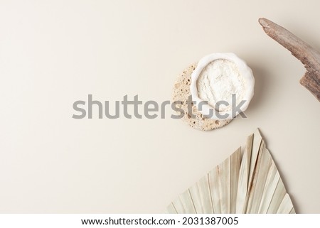 Collagen powder with palm leaf on pastel beige background. Flat lay, copy space
