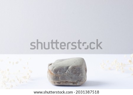 Cosmetic natural background with podium and flowers on grey and white. Close up, copy space