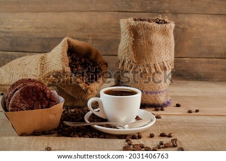 A cup of coffee. A sack of coffee on a wooden background, hot and fresh morning coffee. Fresh coffee. 