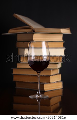 Glass of red wine on a reflective surface with books Royalty-Free Stock Photo #203140816
