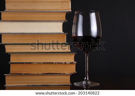 Glass of red wine on a reflective surface with books Royalty-Free Stock Photo #203140822