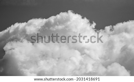 clouds in the sky are cumulus, black and white photo.