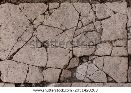 Old aged damaged marble bumpy uneven blocks. Trip pitted grunge granite tile cobble. Cragged grimy retro cranny frayed run track. Crannied dirtied shabby smashed gaping rustic big holes for 3d design Royalty-Free Stock Photo #2031420203