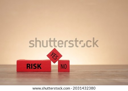 Risk concept. Wooden blocks with letterings RISK, YES, and NO. Noise is visible due to the subject texture
