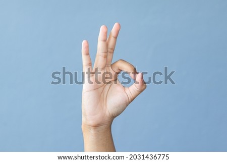 Hand man making ok sign on grey background