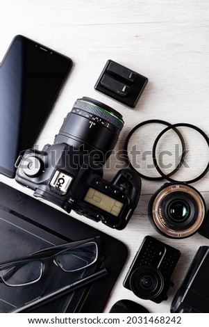 Professional Photographic Equipment and digital photo edit and retouching.Digital photo workstation over white background.Top view of  digital camera, flash,lens and laptop.