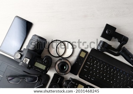 Professional Photographic Equipment and digital photo edit and retouching.Digital photo workstation over white background.Top view of  digital camera, flash,lens and laptop.