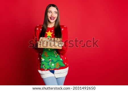 Photo of shocked sweet young lady wear ornament sweater holding toys box looking empty space isolated red color background