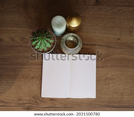 Empty notebook on a wooden table surrounded by candles and plants, Notebook stock photo, Writing inspiration