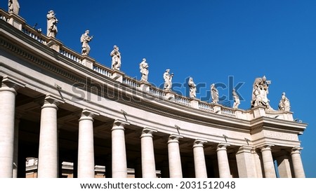 Colonnade of the Basilica of Saint Peter seen in perspective from below. Created by Gian Lorenzo Bernini, it has 140 statues on the top Royalty-Free Stock Photo #2031512048