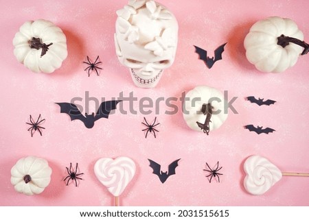 Modern pink Halloween theme flatly background with white skull, pumpkins, lollipops and bats.