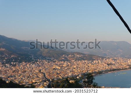Alanya city (Turkey) harbor in the evening. Buildings. Bay with boats and ships. Mountains and sea.