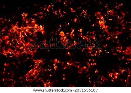 background of burning and glowing hot coals. smoldering embers of fire. flicker of burning coals at night Royalty-Free Stock Photo #2031536189