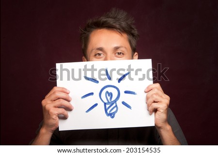Young man with an idea light bulb sign on a card half covering face