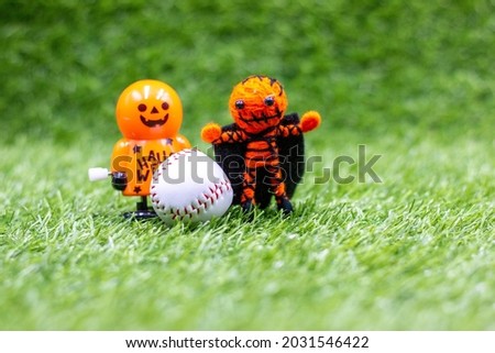 Baseball is on green grass for Halloween Day 