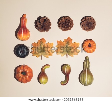 Creative neatly arranged layout with colorful autumn leaves, pumpkins and pinecones on beige background. Flat lay. Season concept.
