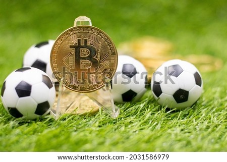 Bitcoin and Soccer Ball are on Green grass for gambling concept. Major Soccer Clubs in Europe Make it  as gateway into speculative cryptocurrency