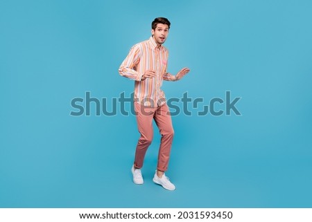 Full length photo of charming young happy man amazed attractive man walk isolated on pastel blue color background