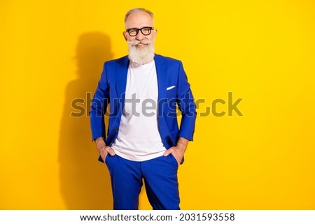 Photo portrait of confident man wearing blue suit glasses smiling happy isolated bright yellow color background