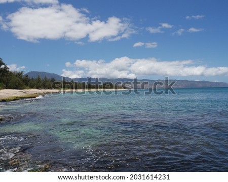 photo of ocean and sandy beach under the blue sky