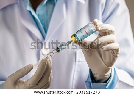 Doctor or scientist filling a syringe with liquid vaccines booster. fight against virus covid-19 coronavirus, Vaccination and immunization. diseases,medical care,science, vaccine booster concept. Royalty-Free Stock Photo #2031617273