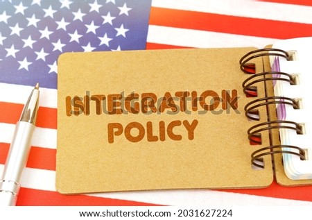 Politics and people concept. On the US flag lies a notebook with the inscription - Integration policy